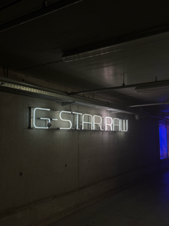 Foto van het G-Star logo in hun parkeergarage, donker